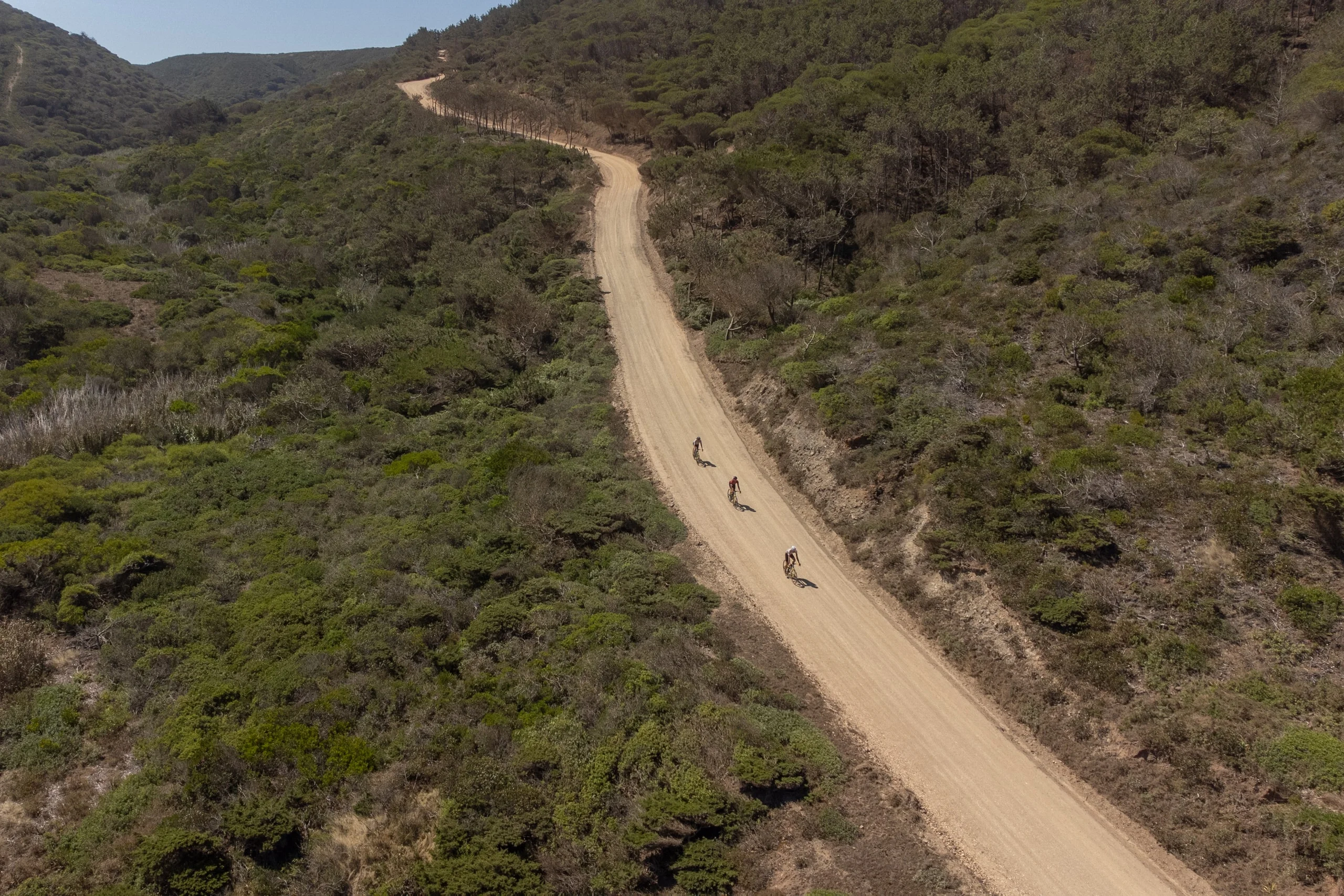 Gravel riders on a forest track west of Lagos, seen from the air