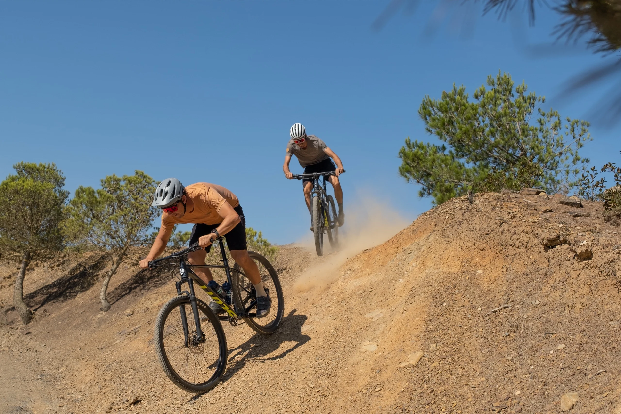 Two mountain bikers on a dusty descent in the hills above Lagos