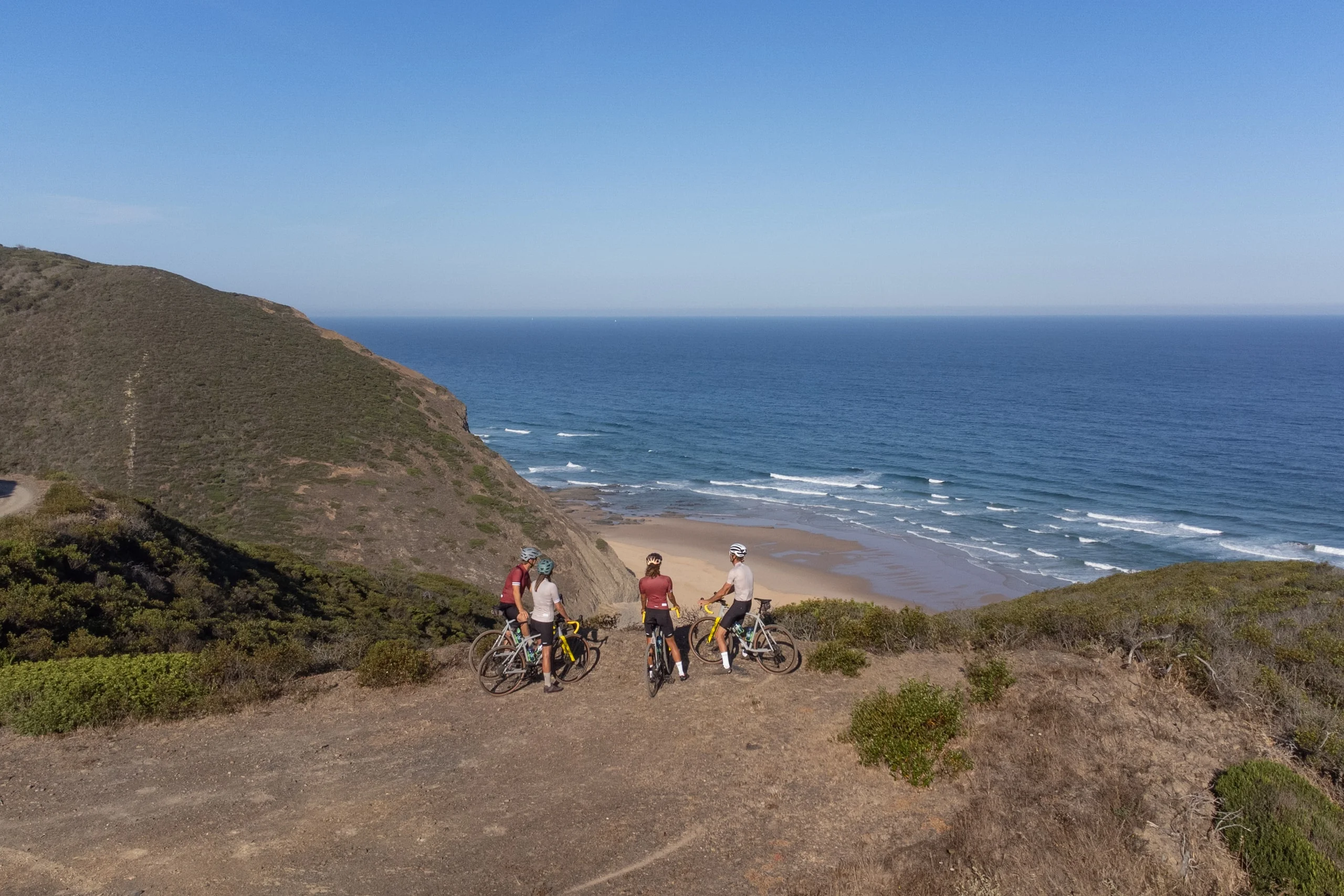 Riders stopped on the cliff above a beach in the park